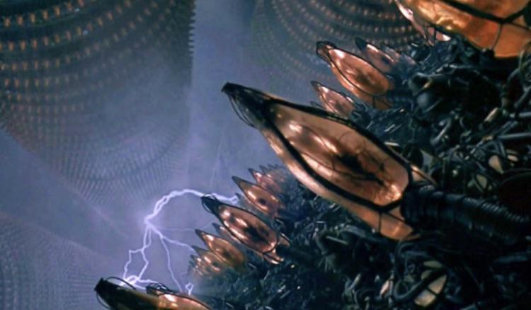 Frame do Filme The Matrix com a imagem onde seres humas "são cultivados" para fornecer energia as máquinas.